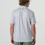 A man modeling the back of a white short sleeve polo with green alligators and golf clubs in an all over pattern