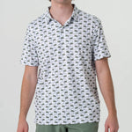 A man wearing a white short sleeve polo with green alligators and golf clubs in an all over pattern