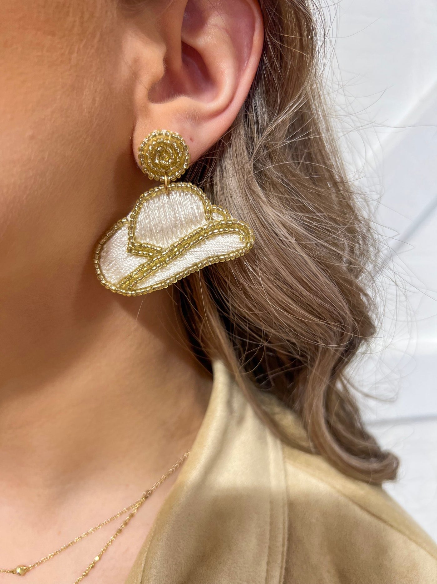 White and gold beaded earrings in shape of cowboy hat